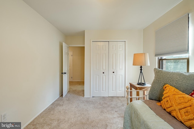 bedroom with a closet and light colored carpet