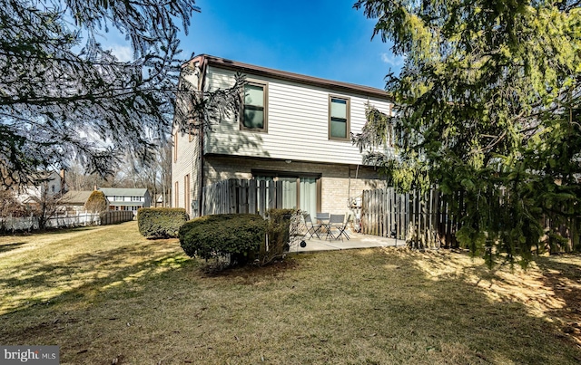 rear view of property with a yard and a patio area