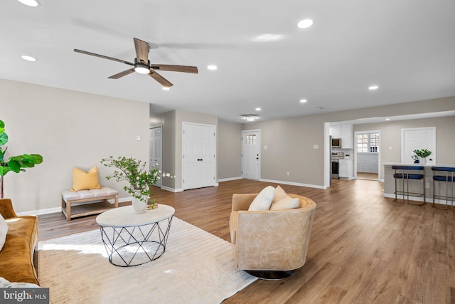 living room featuring ceiling fan and light wood-type flooring