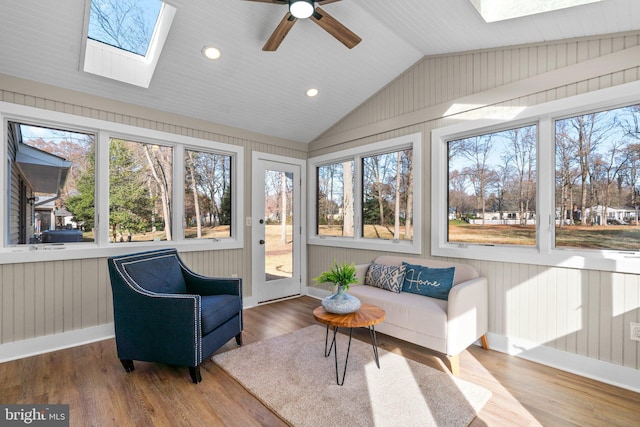 sunroom featuring lofted ceiling with skylight, ceiling fan, and a healthy amount of sunlight