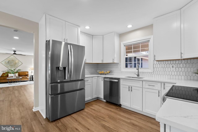 kitchen featuring white cabinets, light hardwood / wood-style floors, sink, and stainless steel appliances