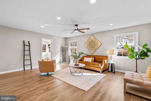 living room with light hardwood / wood-style floors and ceiling fan