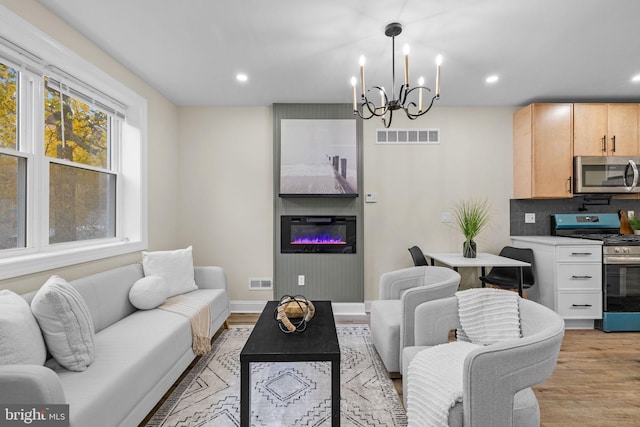 living room featuring a chandelier and light hardwood / wood-style floors