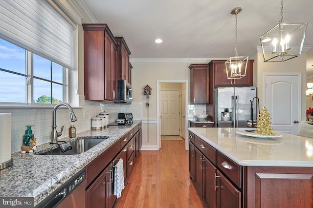 kitchen with decorative backsplash, sink, light wood-type flooring, and appliances with stainless steel finishes