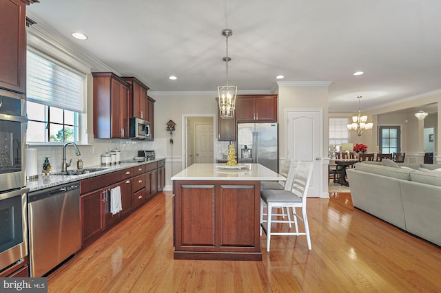 kitchen featuring a kitchen island, sink, light wood-type flooring, and stainless steel appliances