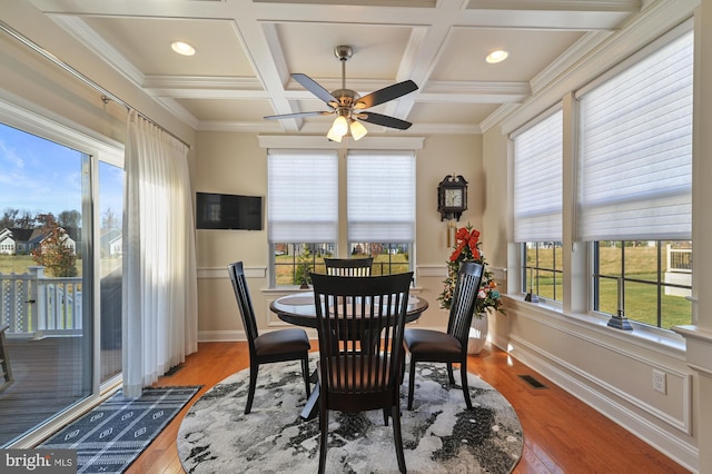 dining room with hardwood / wood-style floors, ornamental molding, and a healthy amount of sunlight