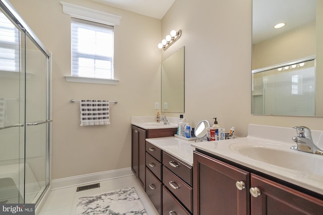 bathroom with tile patterned flooring, vanity, and a shower with shower door