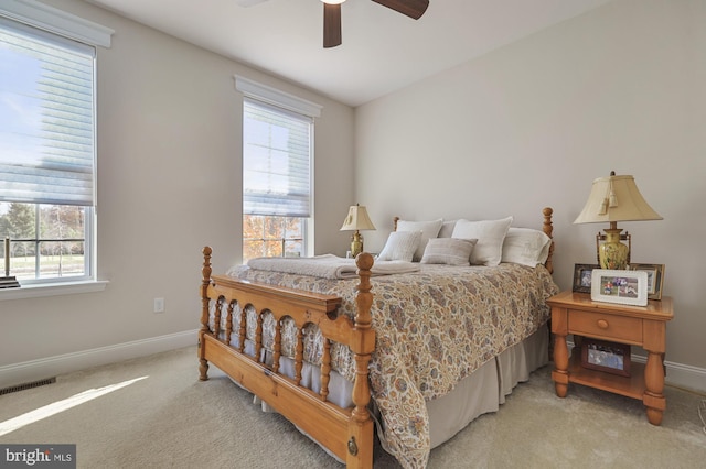 bedroom featuring light colored carpet, multiple windows, and ceiling fan