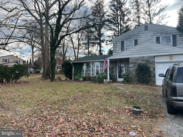 front facade with a garage and a front lawn