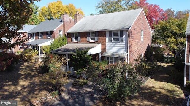 back of property featuring brick siding and a chimney