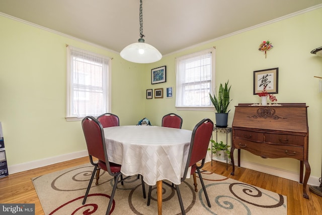 dining room featuring crown molding, plenty of natural light, and wood finished floors