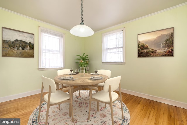 dining room with crown molding, light wood finished floors, baseboards, and a wealth of natural light