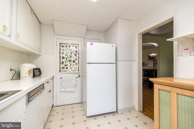 kitchen featuring light floors, white appliances, white cabinetry, and light countertops