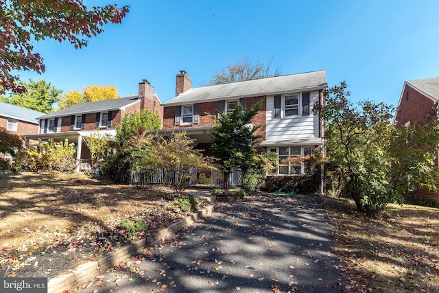 rear view of property with brick siding and a chimney