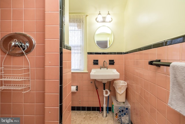 bathroom featuring a sink, tile walls, wainscoting, and tile patterned floors