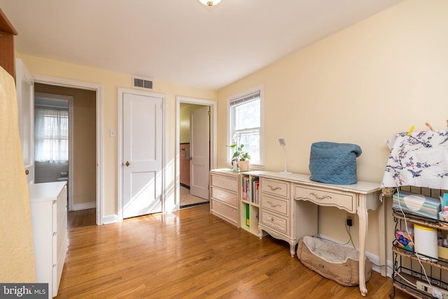 office area with baseboards, visible vents, and light wood finished floors