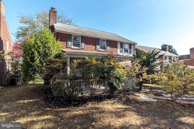 view of front of home with brick siding and a chimney