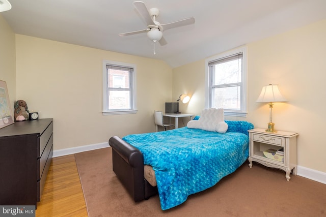 bedroom with baseboards, multiple windows, and wood finished floors