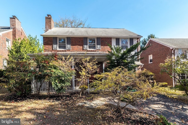 view of front of house featuring brick siding and a chimney