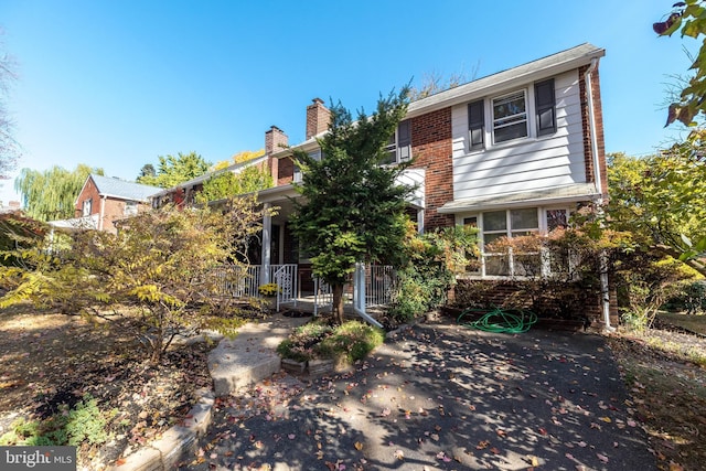 view of front of house featuring brick siding and a chimney