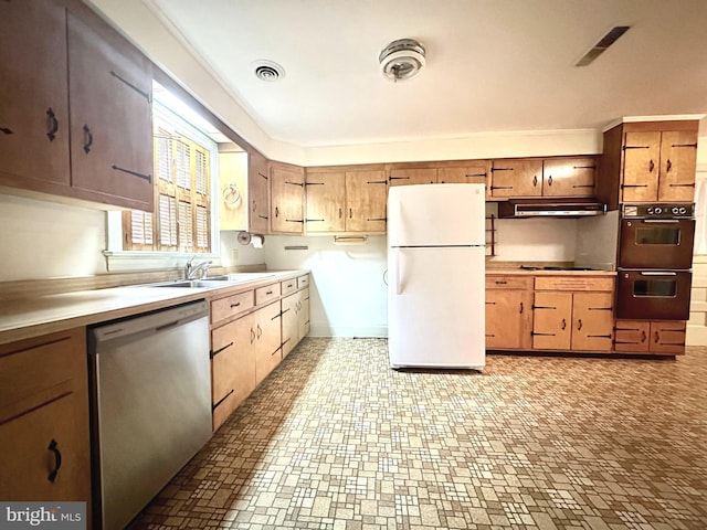 kitchen featuring white refrigerator, stainless steel dishwasher, double oven, and sink