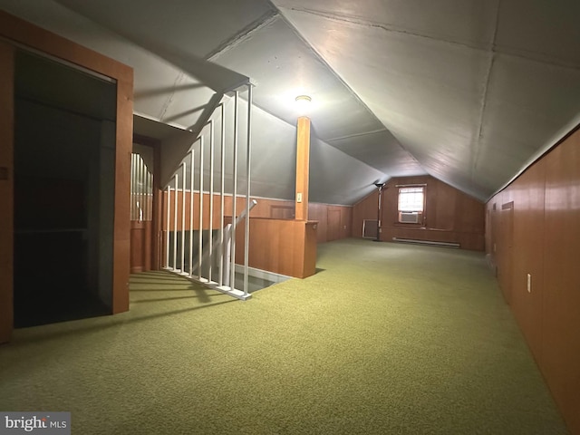 bonus room with carpet flooring, wood walls, and vaulted ceiling