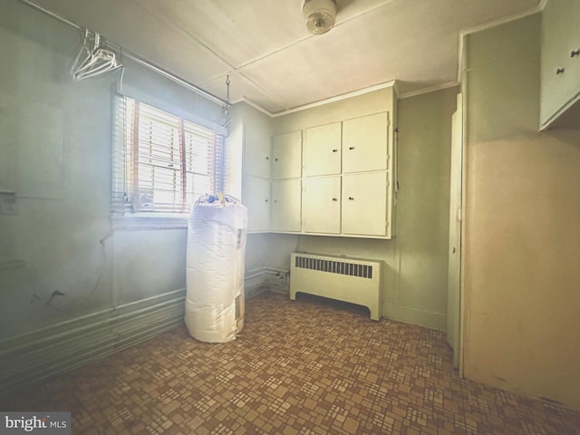 basement featuring radiator and ornamental molding