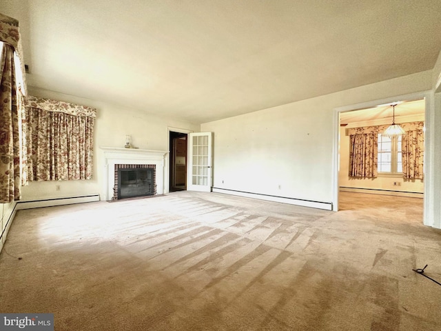 unfurnished living room with baseboard heating, carpet floors, and a brick fireplace