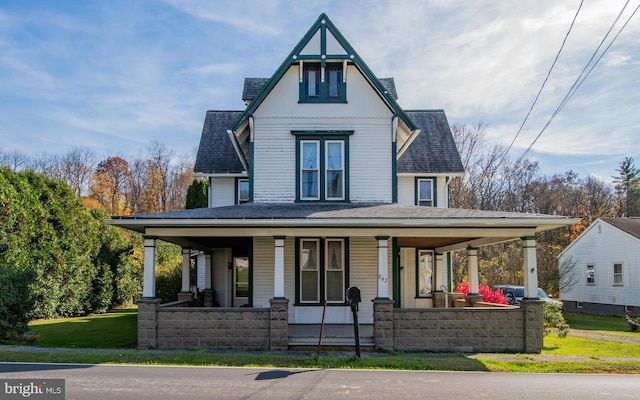 view of front of home featuring covered porch and a front yard