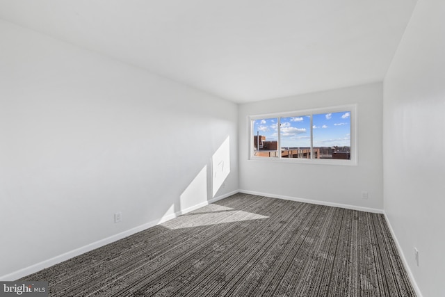 empty room featuring dark carpet