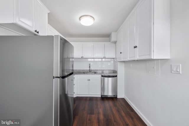 kitchen with sink, dark hardwood / wood-style floors, light stone counters, white cabinetry, and stainless steel appliances