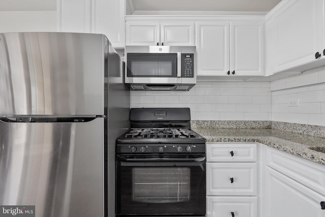 kitchen featuring tasteful backsplash, light stone countertops, white cabinets, and appliances with stainless steel finishes