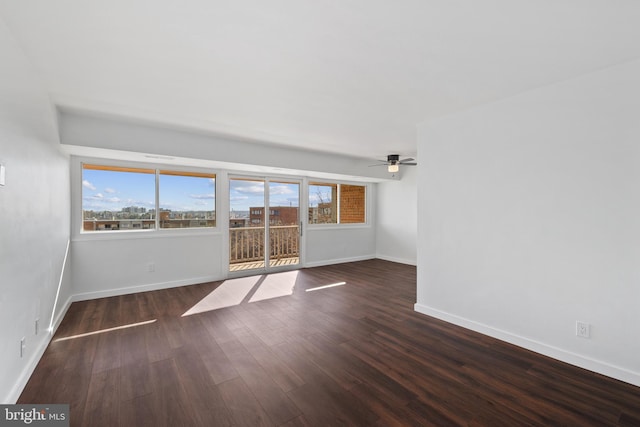 empty room with ceiling fan and dark wood-type flooring