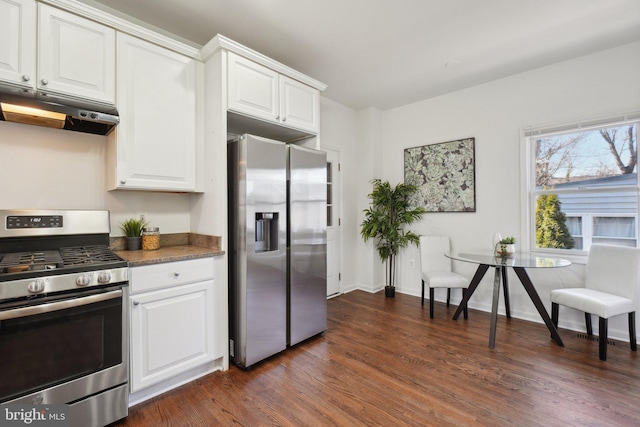 kitchen with under cabinet range hood, white cabinetry, appliances with stainless steel finishes, dark wood-style floors, and breakfast area