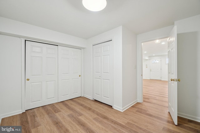 unfurnished bedroom with baseboards and light wood-style floors