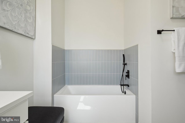 full bath featuring a garden tub and vanity