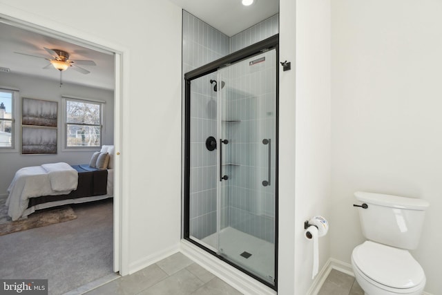 ensuite bathroom featuring tile patterned flooring, toilet, and a shower stall