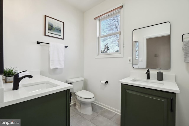 bathroom with toilet, tile patterned floors, baseboards, and vanity