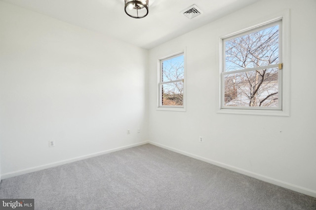 carpeted empty room with baseboards and visible vents