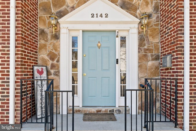 entrance to property featuring stone siding and brick siding