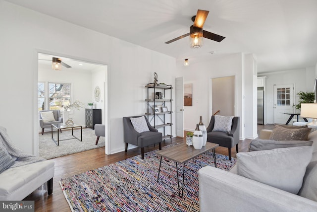 living area with ceiling fan, baseboards, and wood finished floors