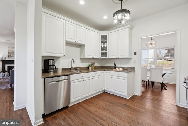 kitchen with a sink, dark wood-style floors, white cabinets, and stainless steel dishwasher