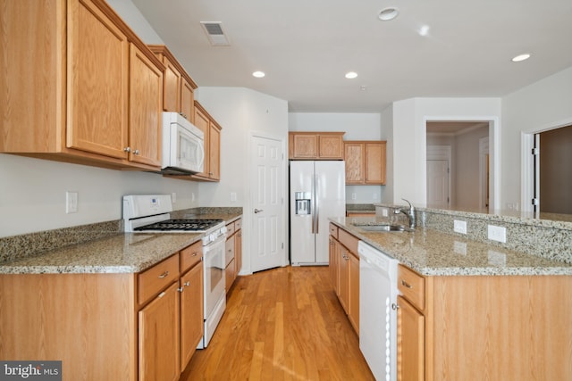 kitchen featuring white appliances, light hardwood / wood-style floors, light stone counters, and sink