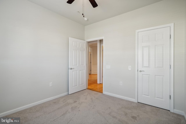 unfurnished bedroom featuring light carpet and ceiling fan