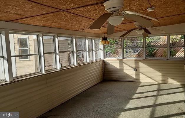 unfurnished sunroom featuring ceiling fan