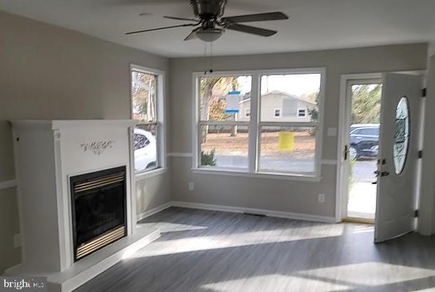 unfurnished living room featuring ceiling fan and hardwood / wood-style floors