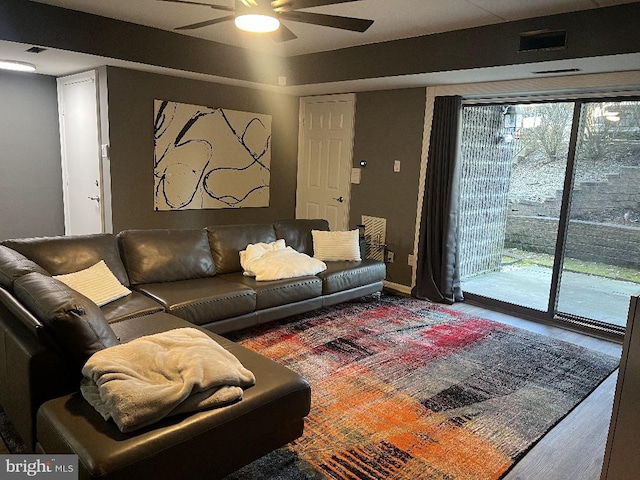 living room featuring wood-type flooring and ceiling fan