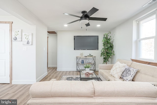 living room with light hardwood / wood-style floors and ceiling fan