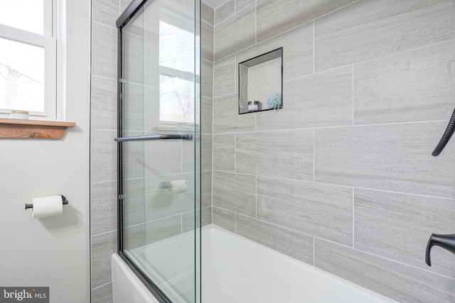 bathroom featuring bath / shower combo with glass door