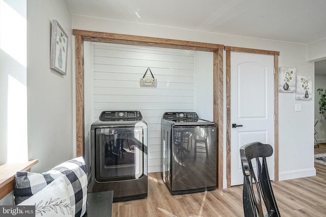 laundry room featuring washer and dryer and light hardwood / wood-style flooring